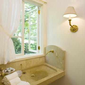 Powder Room with carved stone sink and wall mounted faucet