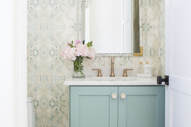 Transitional marble floor and gray floor powder room photo in Other with shaker cabinets, green cabinets, a one-piece toilet, an undermount sink, marble countertops, white countertops and multicolored walls