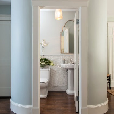 Small elegant white tile and mosaic tile dark wood floor powder room photo in Boston with a pedestal sink, a two-piece toilet and white walls
