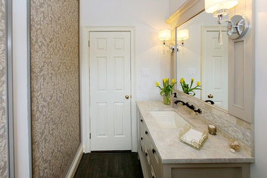 Example of a mid-sized transitional plywood floor powder room design in Philadelphia with furniture-like cabinets, white cabinets, a two-piece toilet, beige walls, an undermount sink, marble countertops and beige countertops