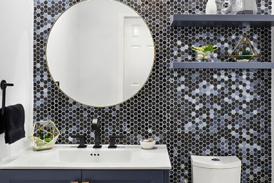 Design ideas for a small contemporary cloakroom in Toronto with recessed-panel cabinets, blue cabinets, multi-coloured tiles, mosaic tiles, white walls, an integrated sink and white worktops.