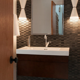 Cette image montre un WC et toilettes vintage de taille moyenne avec un lavabo suspendu, un placard à porte plane, des portes de placard en bois brun, un carrelage gris, un carrelage de pierre et un mur blanc.