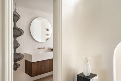 Powder room - mid-sized modern white tile and limestone tile light wood floor and beige floor powder room idea in San Francisco with flat-panel cabinets, medium tone wood cabinets, a wall-mount toilet, white walls, an undermount sink, limestone countertops, white countertops and a floating vanity