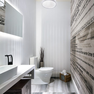 Diseño de aseo actual con lavabo sobreencimera, armarios tipo mueble, sanitario de dos piezas y paredes blancas