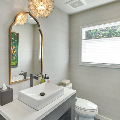 Powder room - large transitional ceramic tile and gray floor powder room idea in San Francisco with a two-piece toilet, gray walls, a vessel sink, solid surface countertops and white countertops