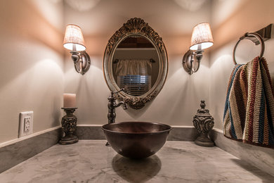 ローリーにある中くらいな地中海スタイルのおしゃれなトイレ・洗面所 (白い壁、ベッセル式洗面器、御影石の洗面台、グレーの洗面カウンター) の写真