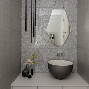 Immagine di un piccolo bagno di servizio minimal con ante lisce, ante grigie, piastrelle grigie, piastrelle di vetro, pareti grigie e lavabo a bacinella