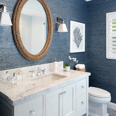 Example of a mid-sized beach style blue tile mosaic tile floor and multicolored floor powder room design in Miami with white cabinets, blue walls, an undermount sink, flat-panel cabinets, marble countertops and white countertops
