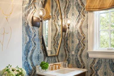 Powder room - mid-sized transitional white floor powder room idea in New York with brown cabinets, blue walls, an undermount sink, marble countertops, white countertops, flat-panel cabinets and a two-piece toilet