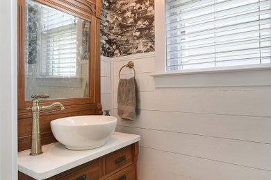 Foto de aseo clásico renovado pequeño con armarios tipo mueble, puertas de armario de madera clara, lavabo sobreencimera, encimera de cuarzo compacto y encimeras blancas