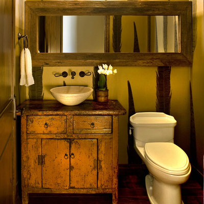 Powder room - mid-sized rustic dark wood floor powder room idea in Phoenix with a vessel sink, furniture-like cabinets, orange cabinets, wood countertops, a two-piece toilet and brown countertops