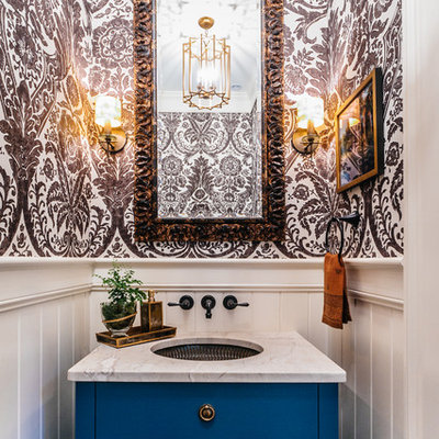 Example of a small transitional powder room design in Charleston with an undermount sink, furniture-like cabinets, blue cabinets, multicolored walls, marble countertops and white countertops