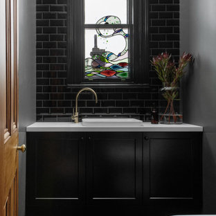 This is an example of a transitional powder room in Hobart with shaker cabinets, black cabinets, a drop-in sink, green floor and a built-in vanity.