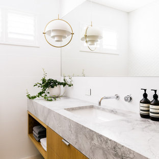 Contemporary powder room in Perth with flat-panel cabinets, medium wood cabinets, white walls, light hardwood floors, an undermount sink and grey benchtops.