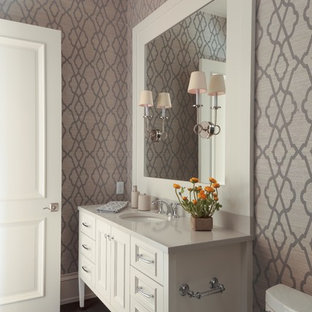 Inspiration för stora klassiska toaletter, med ett undermonterad handfat, luckor med infälld panel, vita skåp, granitbänkskiva, en toalettstol med hel cisternkåpa, brun kakel, grå väggar och mörkt trägolv