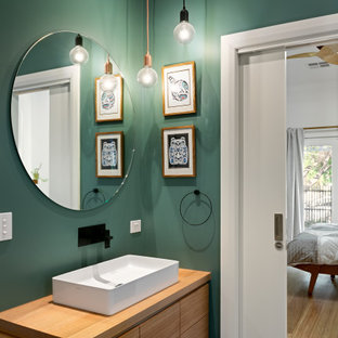 Photo of a contemporary powder room in Melbourne with flat-panel cabinets, medium wood cabinets, green walls, a vessel sink, wood benchtops, grey floor, brown benchtops and a floating vanity.