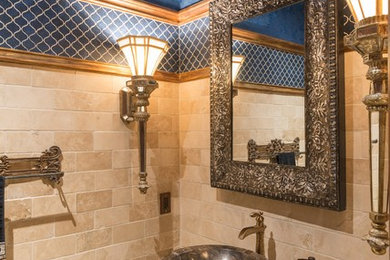 Small elegant beige tile marble floor powder room photo in Austin with a vessel sink, granite countertops and blue walls