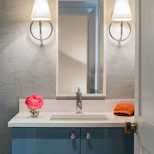 Idées déco pour un WC et toilettes contemporain de taille moyenne avec un lavabo encastré, un placard à porte plane, des portes de placard bleues, un plan de toilette en quartz modifié et un plan de toilette blanc.