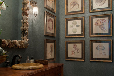 ジャクソンビルにあるトラディショナルスタイルのおしゃれなトイレ・洗面所 (レイズドパネル扉のキャビネット、中間色木目調キャビネット、無垢フローリング、オーバーカウンターシンク、木製洗面台) の写真