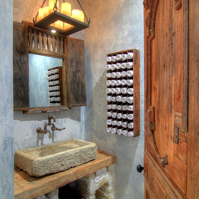 Inspiration for a mediterranean powder room remodel in Houston with a vessel sink, wood countertops, gray walls and brown countertops