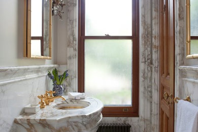 Elegant white floor powder room photo in New York with beige walls, a console sink and multicolored countertops