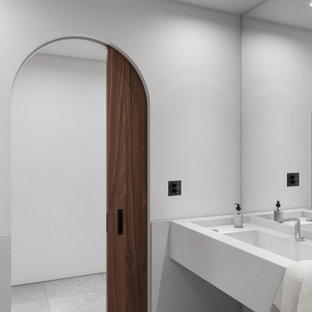 Foto di un ampio bagno di servizio etnico con ante bianche, orinatoio, piastrelle bianche, piastrelle di marmo, pareti bianche, pavimento in pietra calcarea, lavabo integrato, top in marmo, pavimento grigio e top bianco