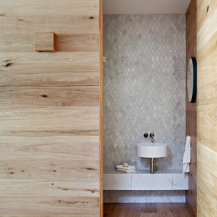 Idées déco pour un WC et toilettes victorien de taille moyenne avec des portes de placard grises, un WC suspendu, un carrelage gris, du carrelage en marbre, un mur blanc, un lavabo suspendu, un plan de toilette en marbre et un plan de toilette gris.