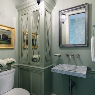 Foto di un piccolo bagno di servizio classico con ante con riquadro incassato, ante verdi, WC a due pezzi, pareti verdi, pavimento in cementine, lavabo sospeso, top in marmo, pavimento beige e top grigio