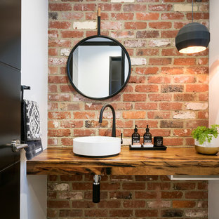 Foto de aseo actual con paredes blancas, lavabo sobreencimera, encimera de madera y encimeras marrones