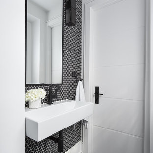Cette image montre un petit WC et toilettes design avec un carrelage noir et blanc, des carreaux de porcelaine, un mur noir, un sol en ardoise, un lavabo suspendu et un sol noir.