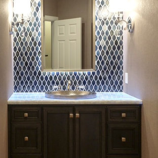Example of a mid-sized transitional blue tile and ceramic tile powder room design in Seattle with a drop-in sink, dark wood cabinets, quartzite countertops, a two-piece toilet, gray walls and recessed-panel cabinets