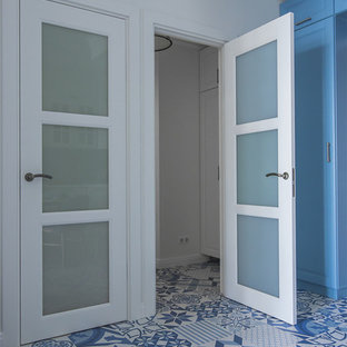 Réalisation d'une petit entrée marine avec un mur blanc, un sol en carrelage de porcelaine et un sol bleu.