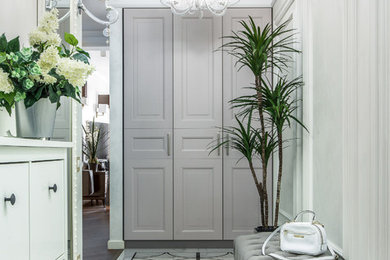 他の地域にあるお手頃価格の中くらいなトラディショナルスタイルのおしゃれな玄関ホール (白い壁、磁器タイルの床、白い床) の写真