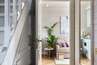 На фото: маленькая узкая прихожая в классическом стиле с серыми стенами, паркетным полом среднего тона, одностворчатой входной дверью, белой входной дверью и коричневым полом для на участке и в саду