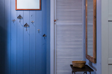 Cette photo montre une petite entrée éclectique avec un mur bleu.