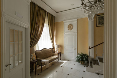Свежая идея для дизайна: фойе среднего размера в классическом стиле с желтыми стенами, полом из керамогранита, белой входной дверью и белым полом - отличное фото интерьера