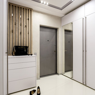 Imagen de puerta principal actual con paredes beige, puerta simple, puerta gris, suelo blanco y suelo de cemento