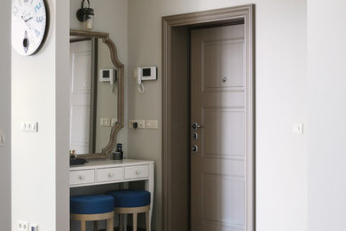 Пример оригинального дизайна: входная дверь в стиле неоклассика (современная классика) с серыми стенами, одностворчатой входной дверью, серой входной дверью и серым полом