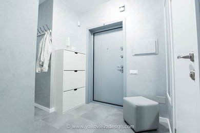 Foto de hall contemporáneo de tamaño medio con paredes grises, suelo de baldosas de porcelana, puerta simple y puerta gris