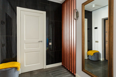 Imagen de puerta principal escandinava pequeña con paredes blancas, suelo de baldosas de porcelana, puerta simple, puerta de madera en tonos medios y suelo gris