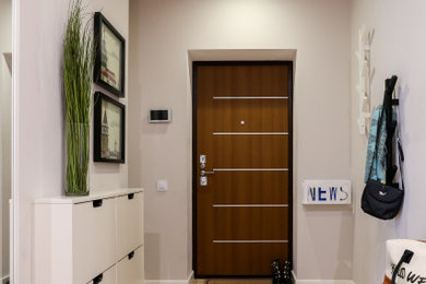 Foto de puerta principal contemporánea pequeña con paredes blancas, suelo de baldosas de porcelana, puerta simple, puerta de madera en tonos medios y suelo beige