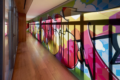 Foto de recibidores y pasillos modernos grandes con paredes multicolor, suelo de madera en tonos medios y suelo marrón