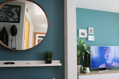 Idée de décoration pour un petit couloir minimaliste avec un mur bleu, sol en stratifié et un sol marron.
