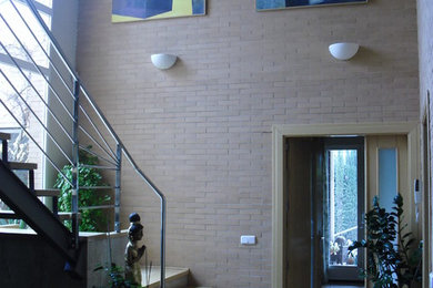 Modelo de recibidores y pasillos contemporáneos de tamaño medio con paredes beige y suelo de baldosas de terracota