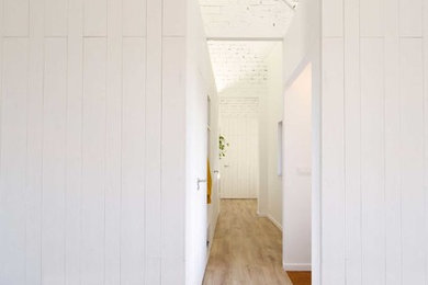 Imagen de recibidores y pasillos nórdicos con paredes blancas, suelo de madera clara y suelo marrón