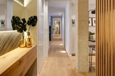 Diseño de recibidores y pasillos actuales pequeños con paredes blancas, suelo de madera clara y suelo beige