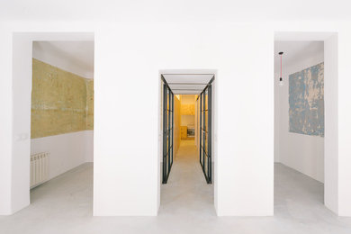 Exemple d'un couloir industriel avec un mur blanc et sol en béton ciré.