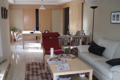 Modelo de sala de estar abierta clásica renovada pequeña sin chimenea con paredes beige y suelo de madera clara