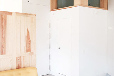Modelo de sala de estar abierta contemporánea de tamaño medio sin chimenea con paredes blancas y suelo de madera en tonos medios