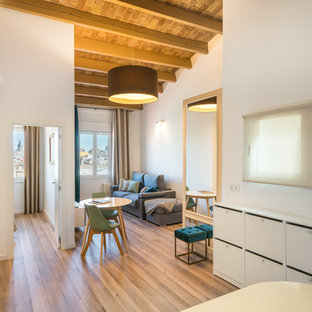 Modelo de sala de estar abierta, clásica renovada, con suelo de madera en tonos medios y paredes blancas